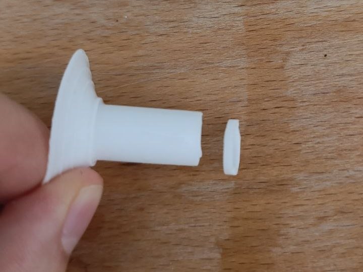 Embout en silicone tenu entre deux doigts, une fine tranche coupée au bout du tube